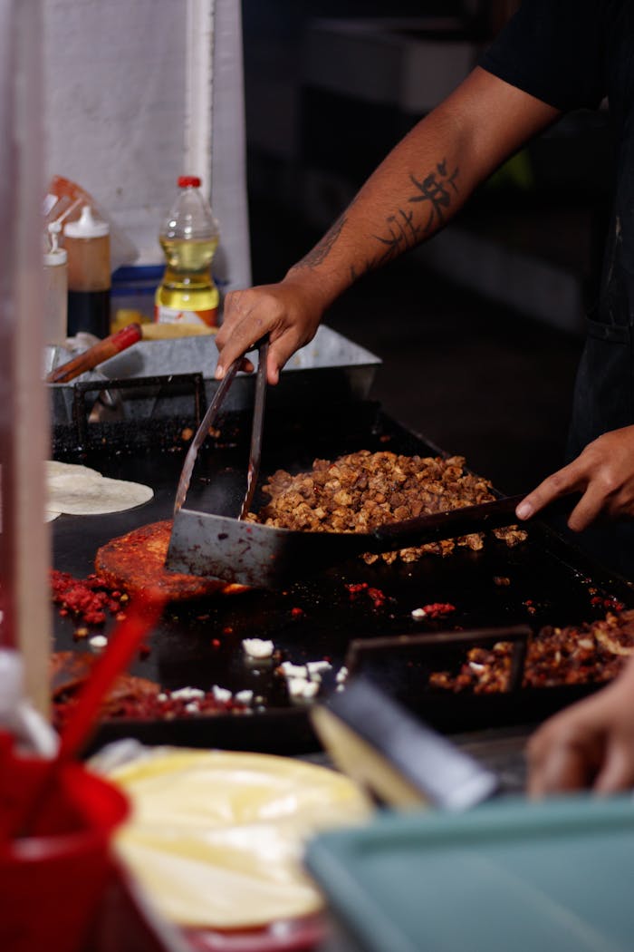 A chef preparing authentic Mexican tacos at a street food stand in Mexico City.